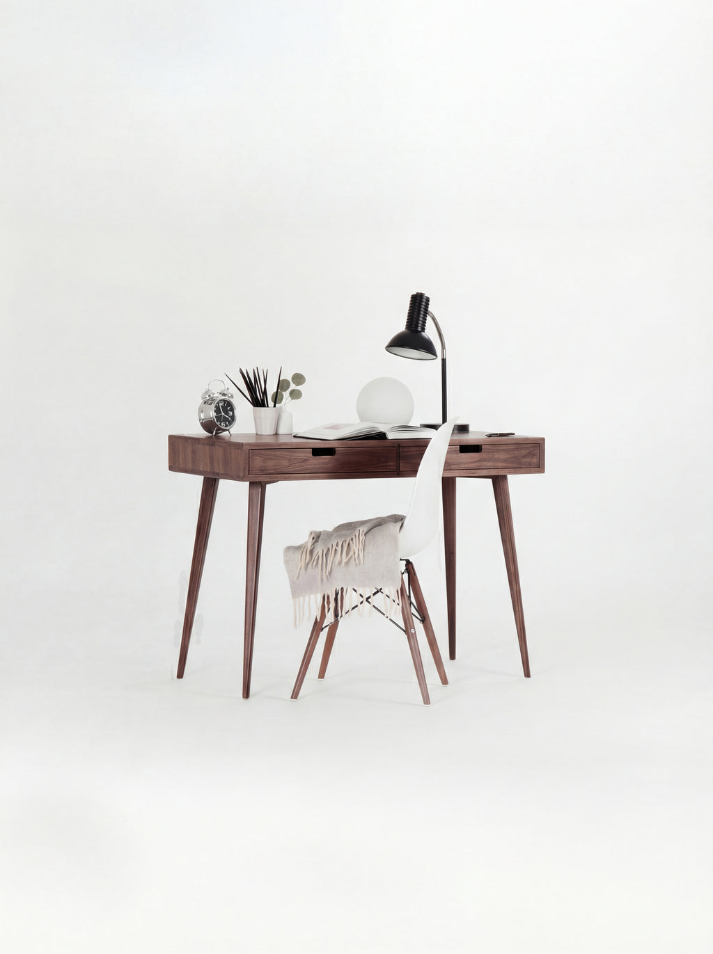 HEIM 105 desk in solid walnut with a white shell chair draped with a fringed blanket