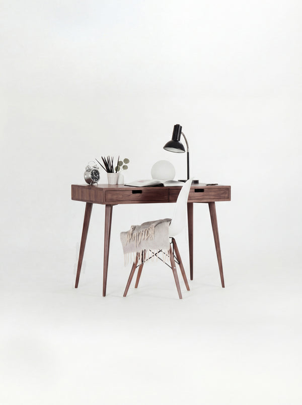 HEIM 105 desk in solid walnut with a white shell chair draped with a fringed blanket