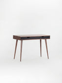 Angled view of the HEIM 105 desk in walnut wood with two black drawer fronts and a bare top