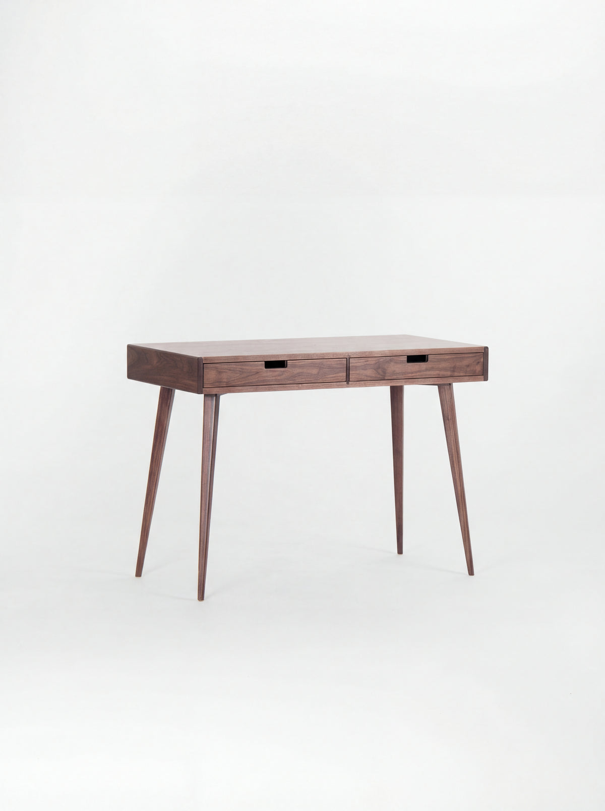 HEIM 105 desk in walnut wood with a bare top and two wooden drawer fronts, shown at an angle