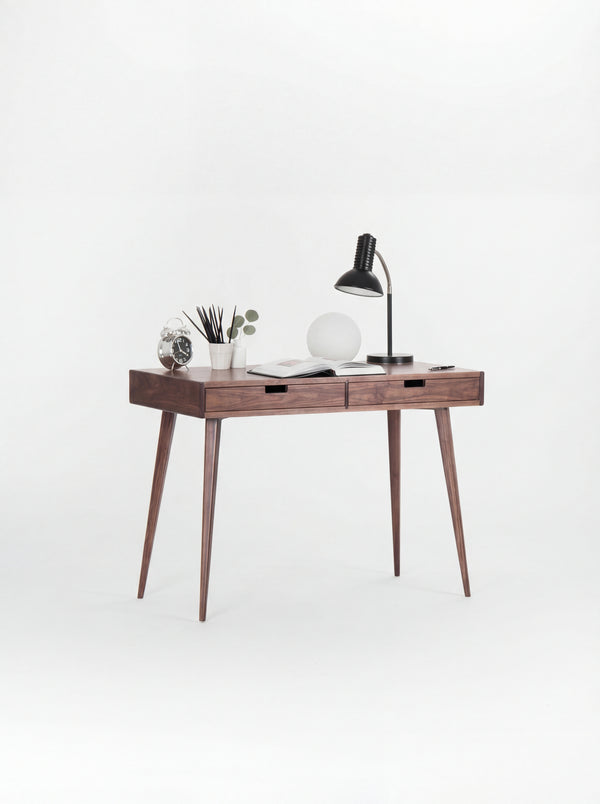 HEIM 105 small desk with drawers in walnut wood, angled view with two lamps and an open book