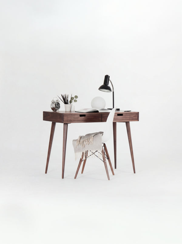 HEIM 105 desk in walnut wood with a white shell chair draped with a fringed blanket