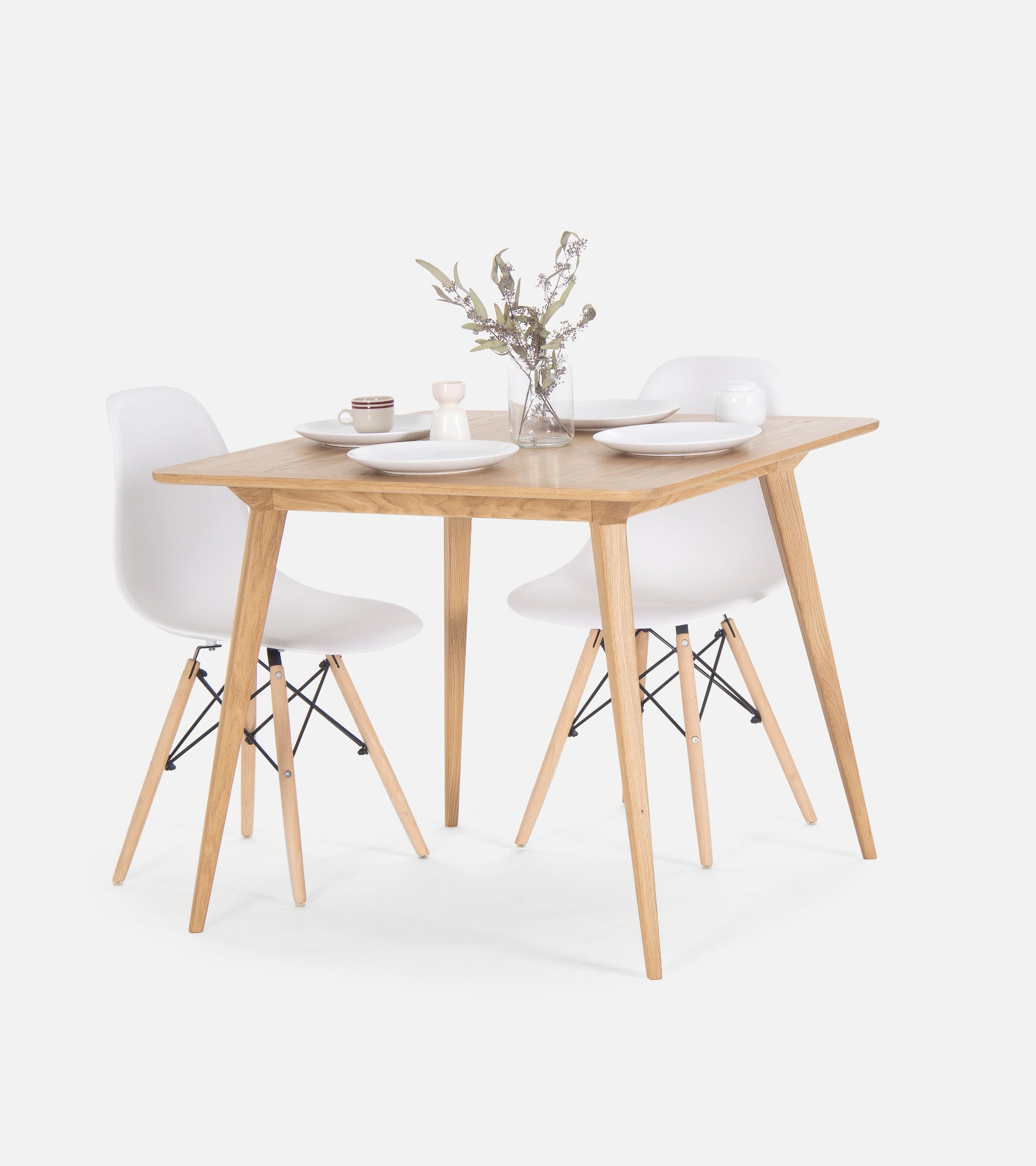 Minimalist dining set with a wooden table, two white chairs, and simple dishware.