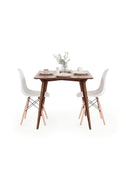YRKE small space dining table in solid American walnut, square top, front view with two white chairs, plates and eucalyptus