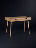 Empty HEIM 105 desk in oak wood on a dark background, angled to show wooden drawer fronts and splayed legs