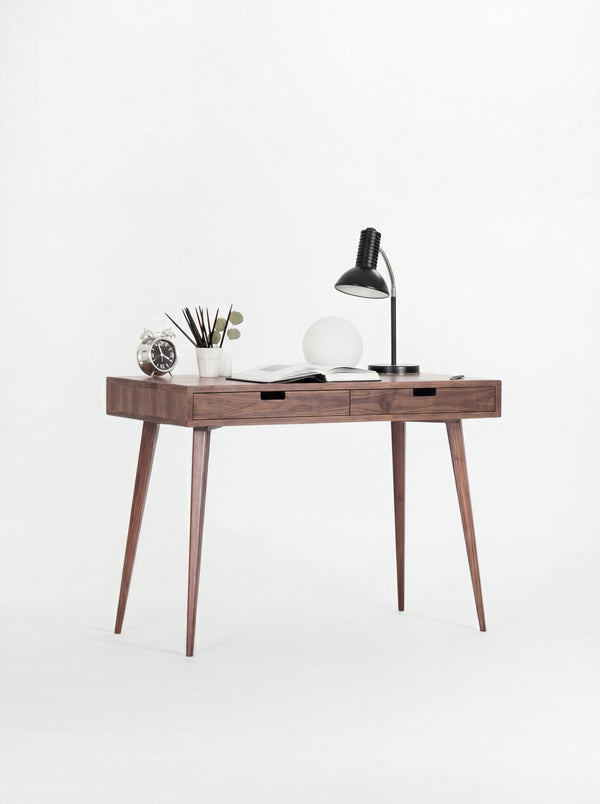 HEIM 105 small writing desk in solid walnut, slightly angled with a clock, pencil cup and open book