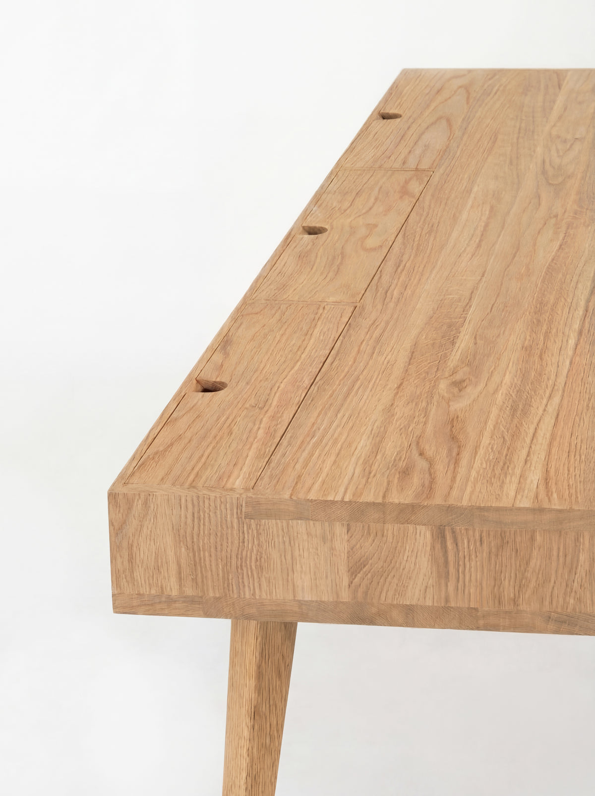 HEIM 140 solid oak desk, close-up of three flush cable flaps and joined wood strips across the top and edge
