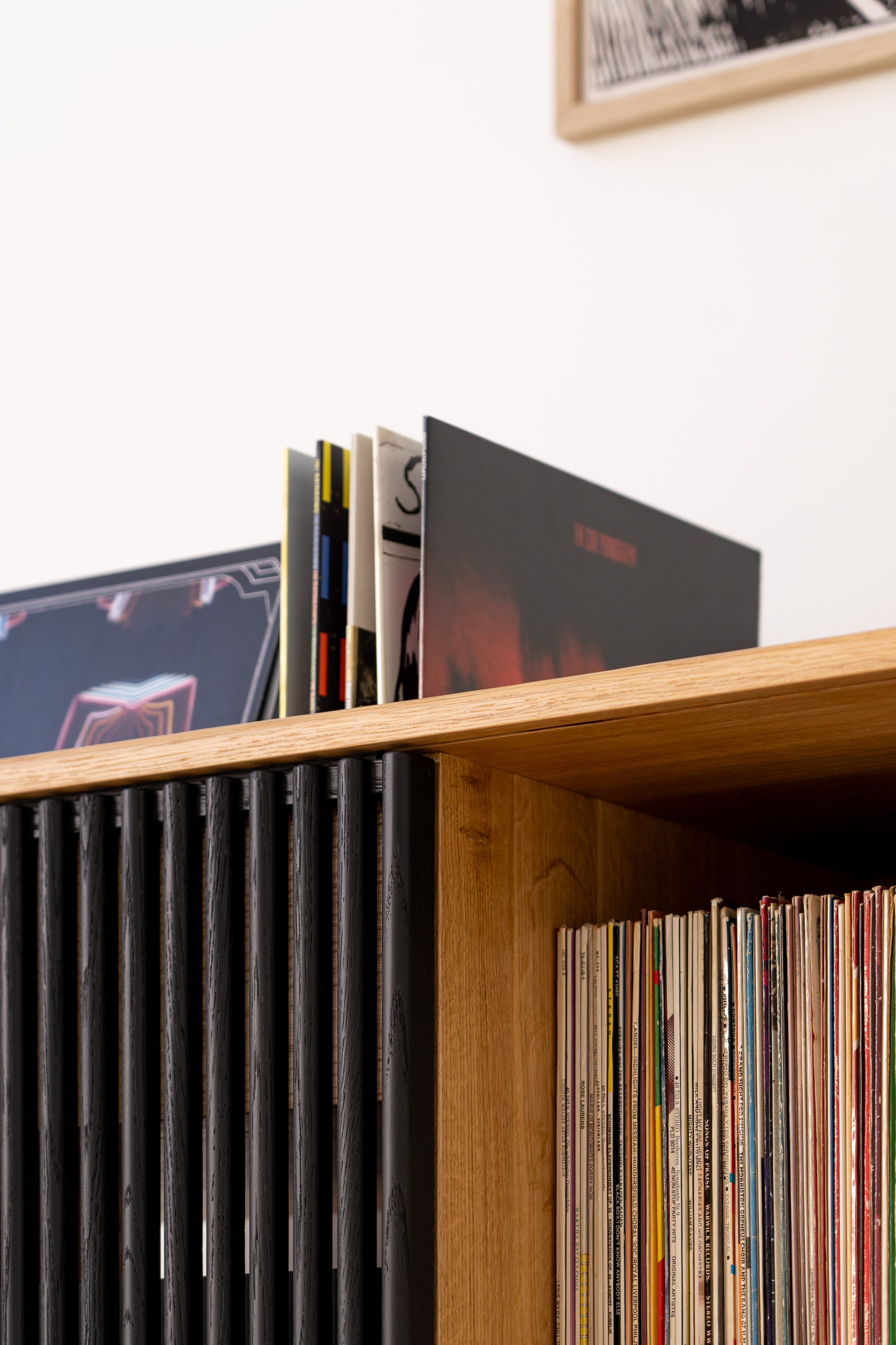 Wooden shelf with vinyl records displayed.