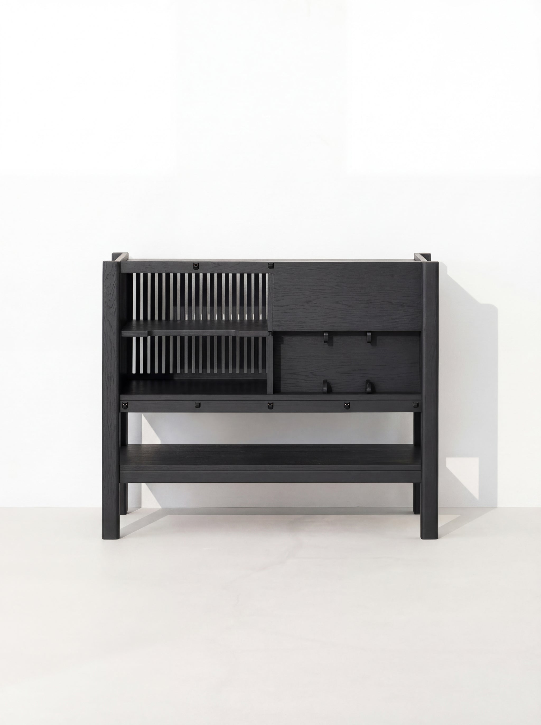 Black, modern cabinet with slatted left side and closed right side, set against a white background.