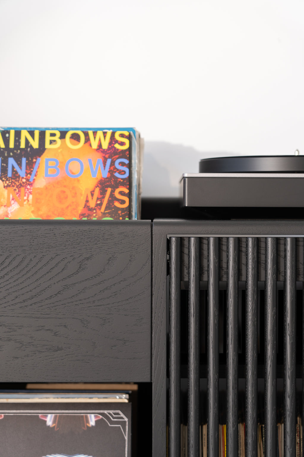 Vinyl records in a black cabinet, with a turntable on top.