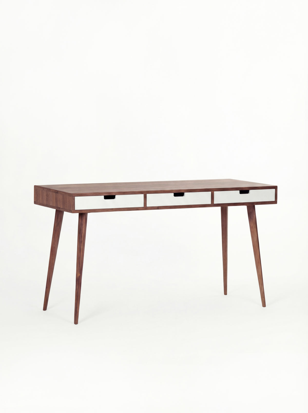 HEIM 140 desk in solid walnut with three white drawer fronts, empty and shown at a three-quarter angle