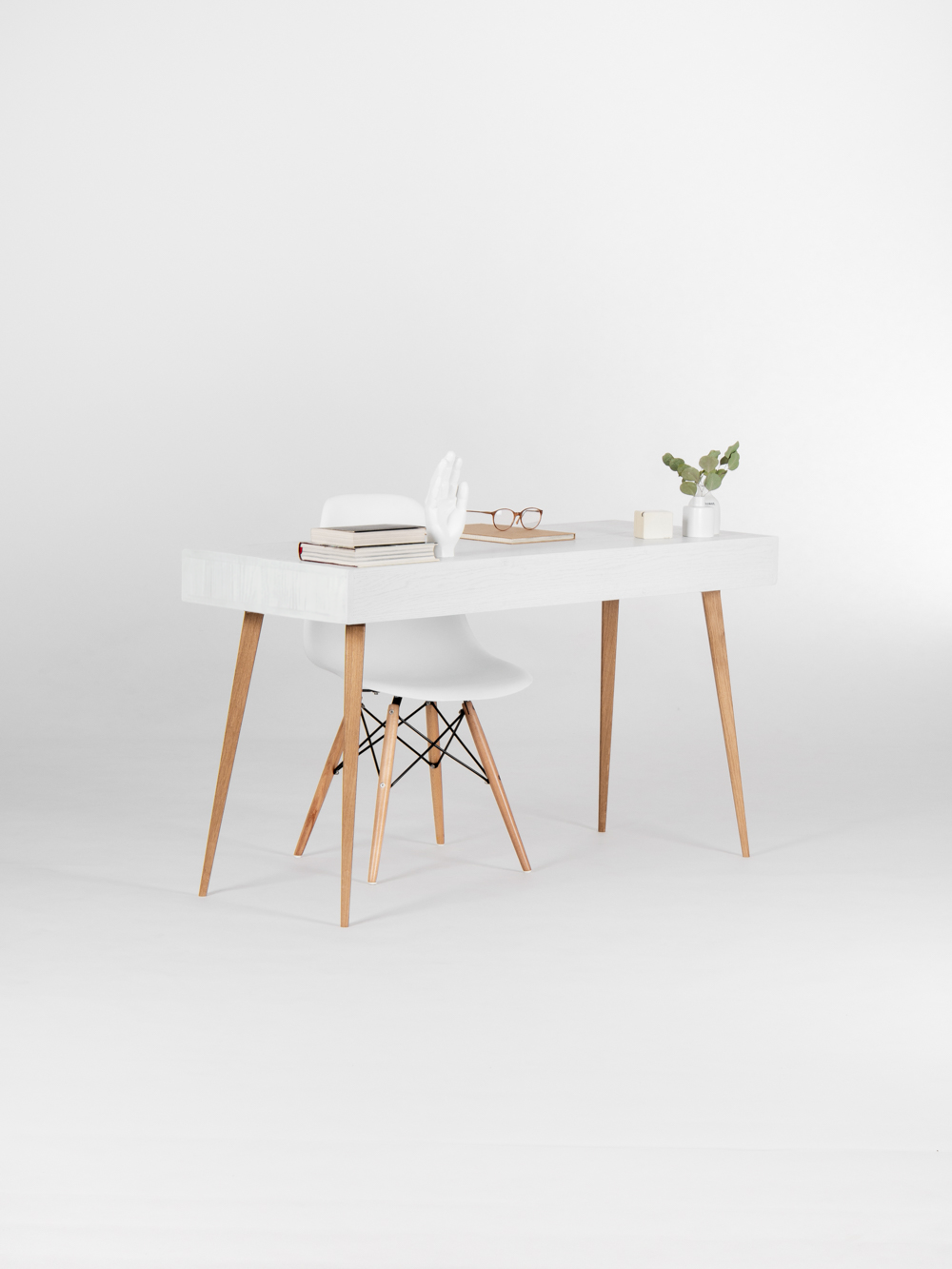 HEIM 140 desk in solid oak, rear view with a plain white panel, natural oak legs and a shell chair