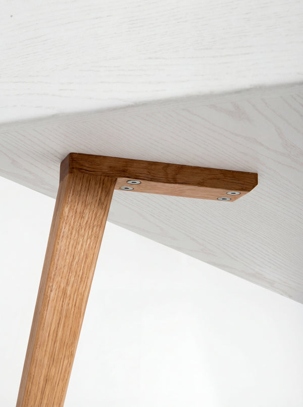 HEIM 140 desk in oak wood, viewed from below with screws securing an oak leg to its mounting block