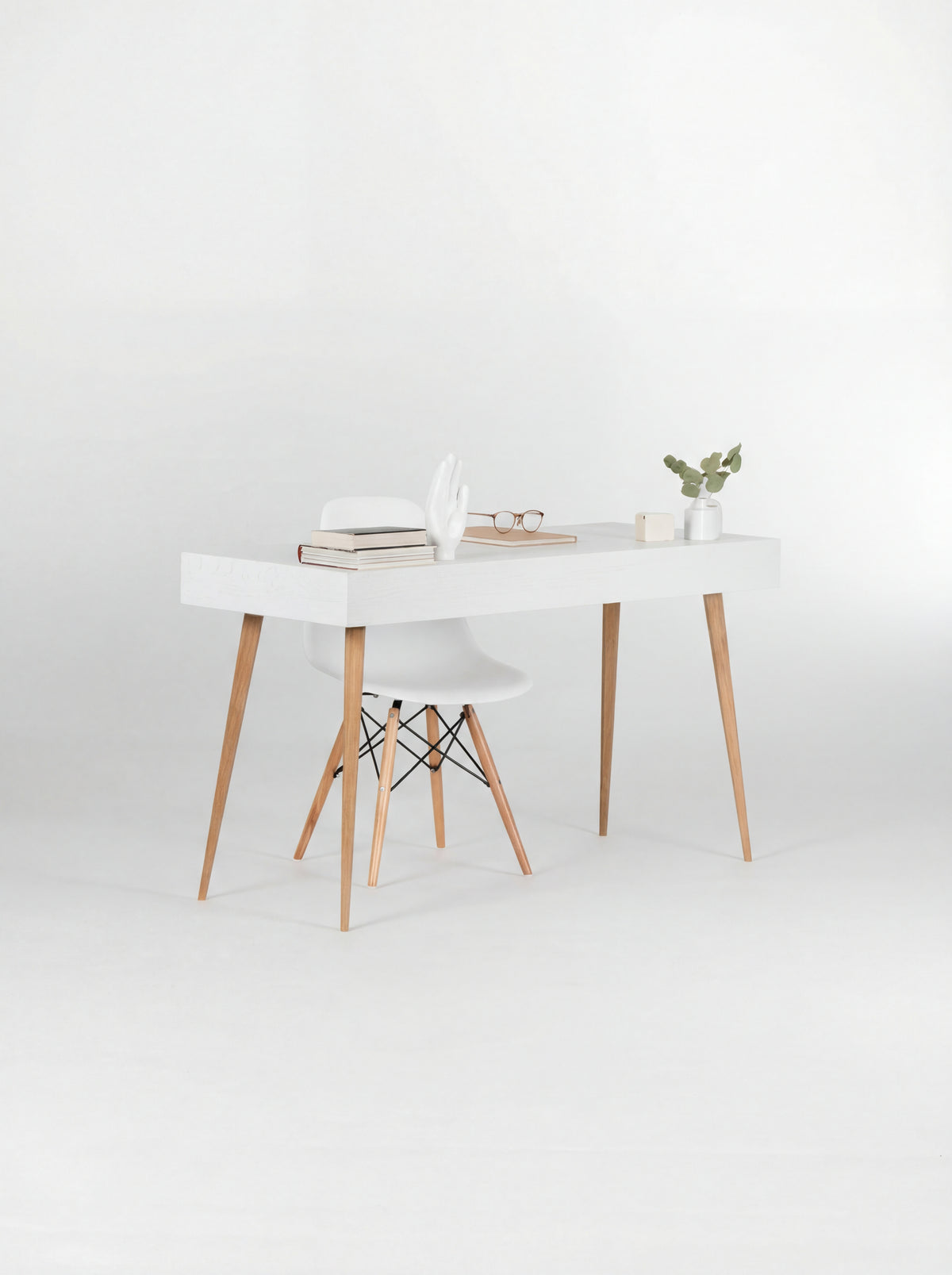 Rear view of the HEIM 140 desk in oak wood, with a plain white panel, oak legs and a white shell chair