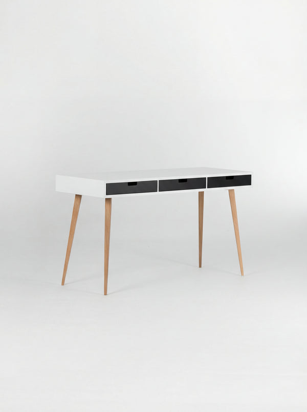 HEIM 140 desk in oak wood with a white body and three black drawer fronts, shown empty at a three-quarter angle