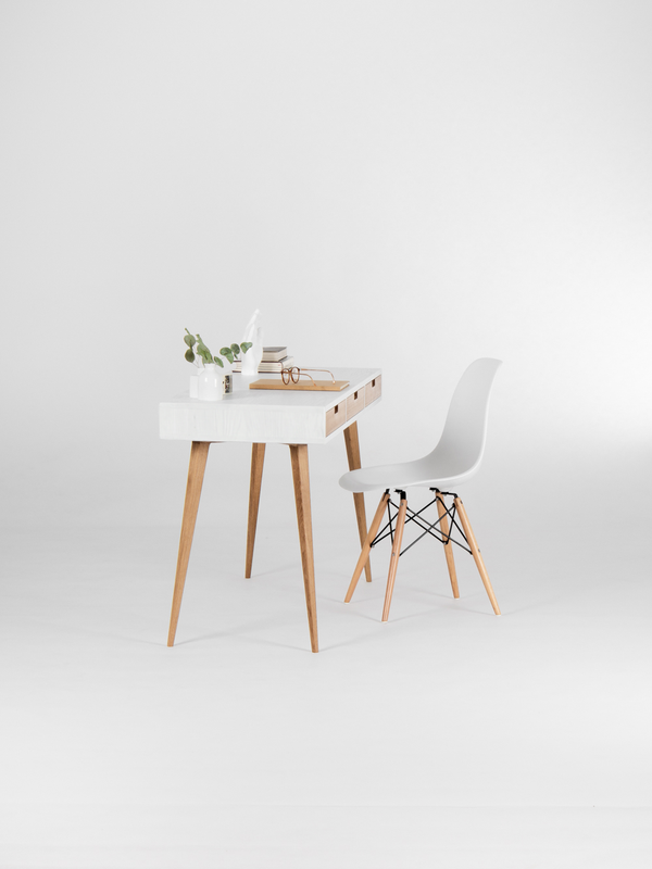 HEIM 140 white wood desk in solid oak, seen from the short end with grain visible on the side and a shell chair