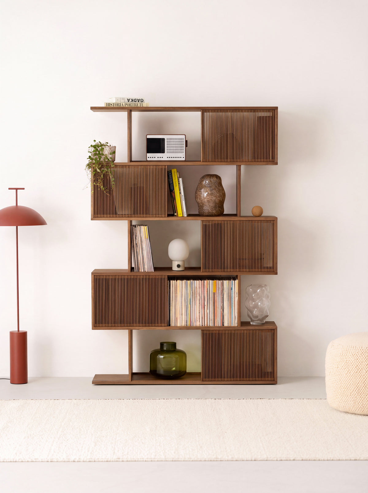 MOLL wood bookshelf in solid walnut, front view with five slatted fronts, books, records, a radio and glass vases