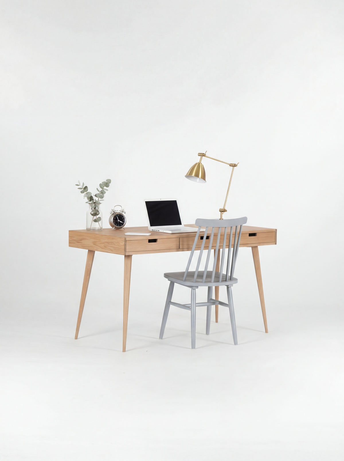 HEIM 140 oak wood computer desk with a grey spindle chair pulled up and a laptop on top