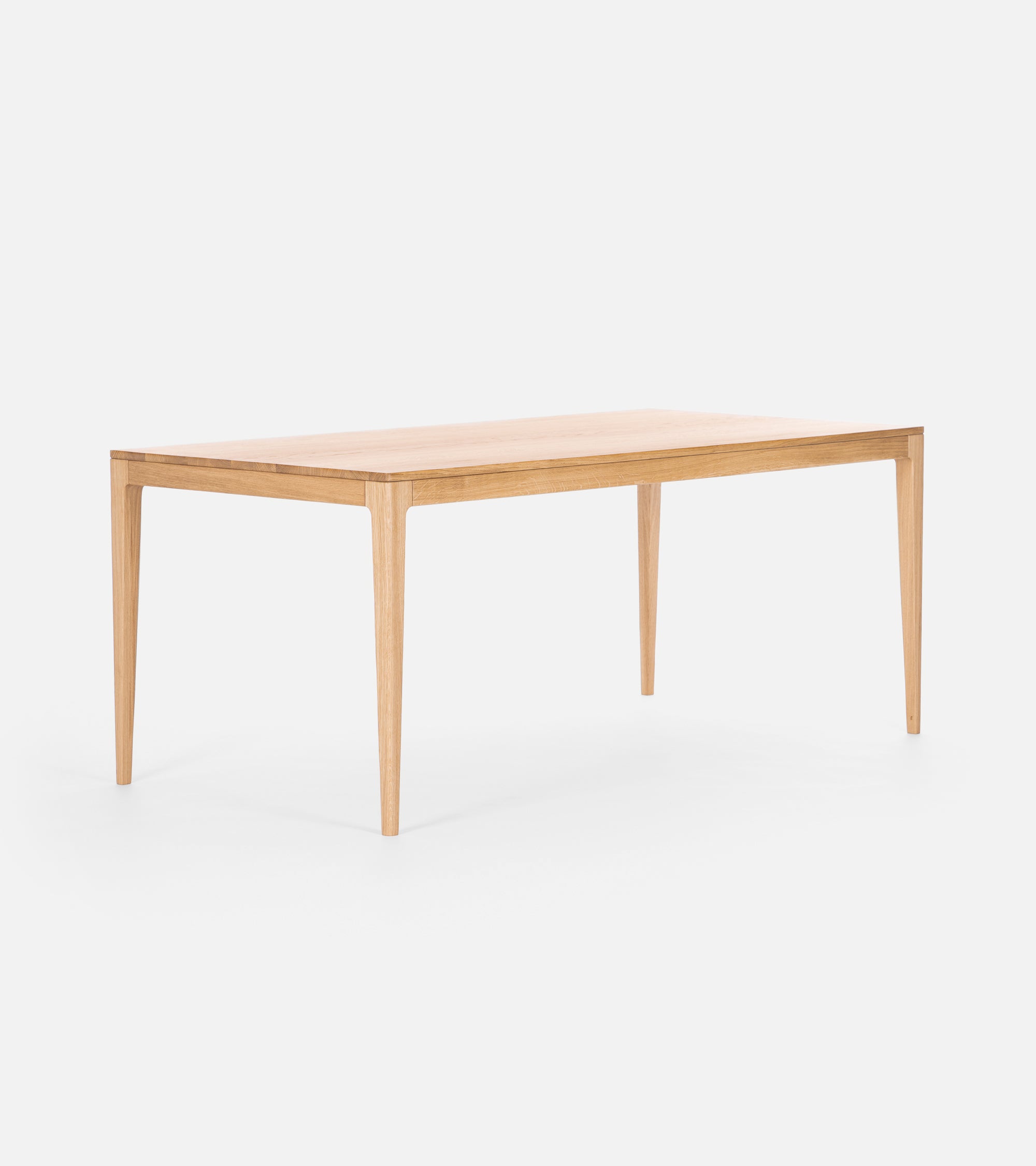 A minimalist wooden dining table with four square-tapered legs.
