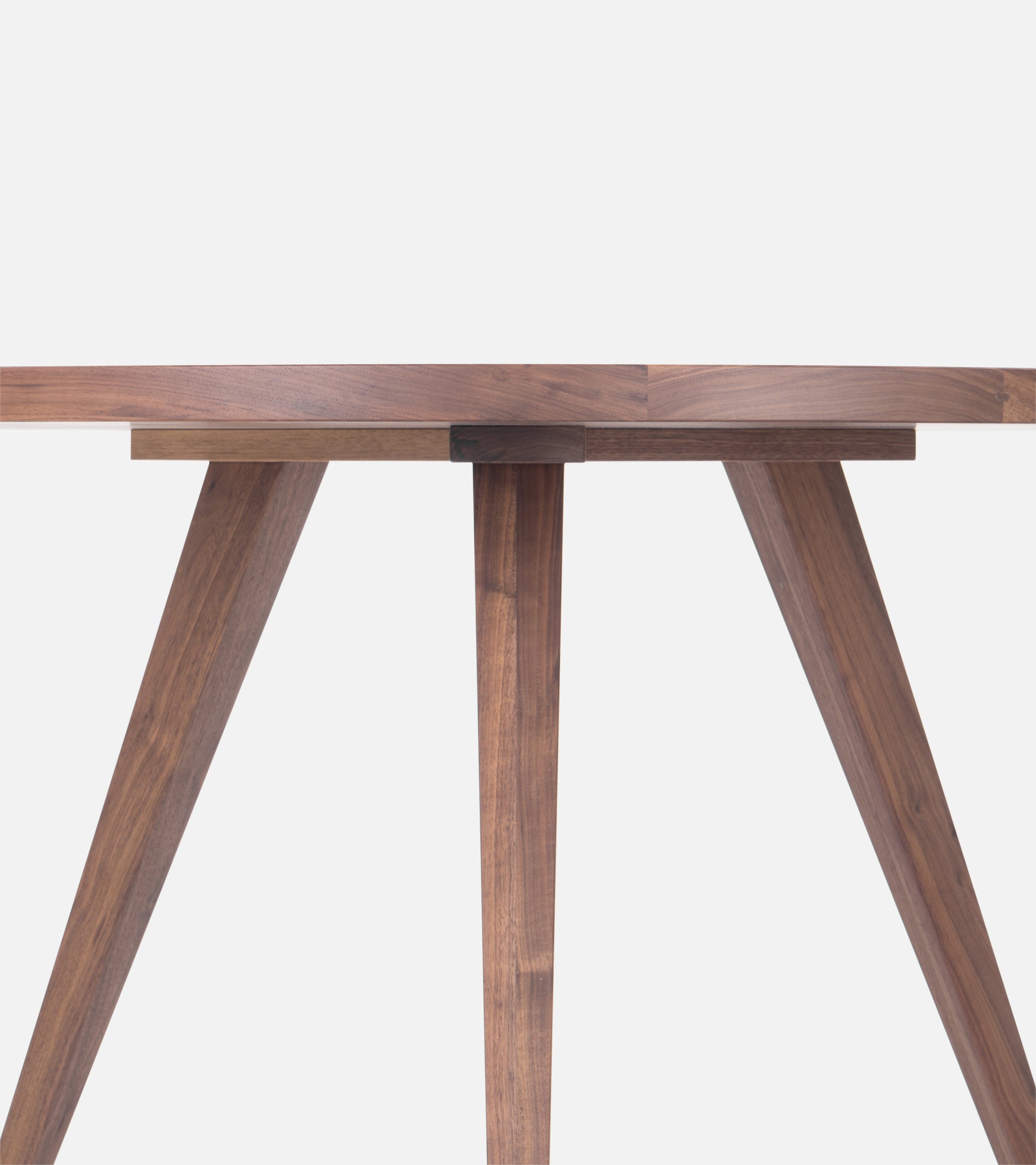  Close-up of a wooden table's legs and underside, highlighting the clean, geometric design and natural wood grain.