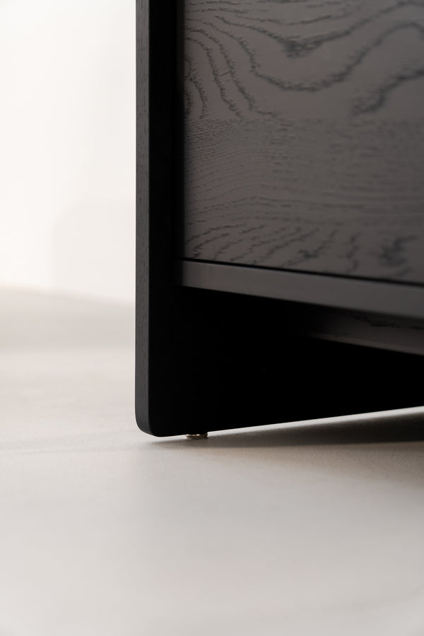 Close-up of a black wooden corner, focusing on floor surface with visible wood grain texture.