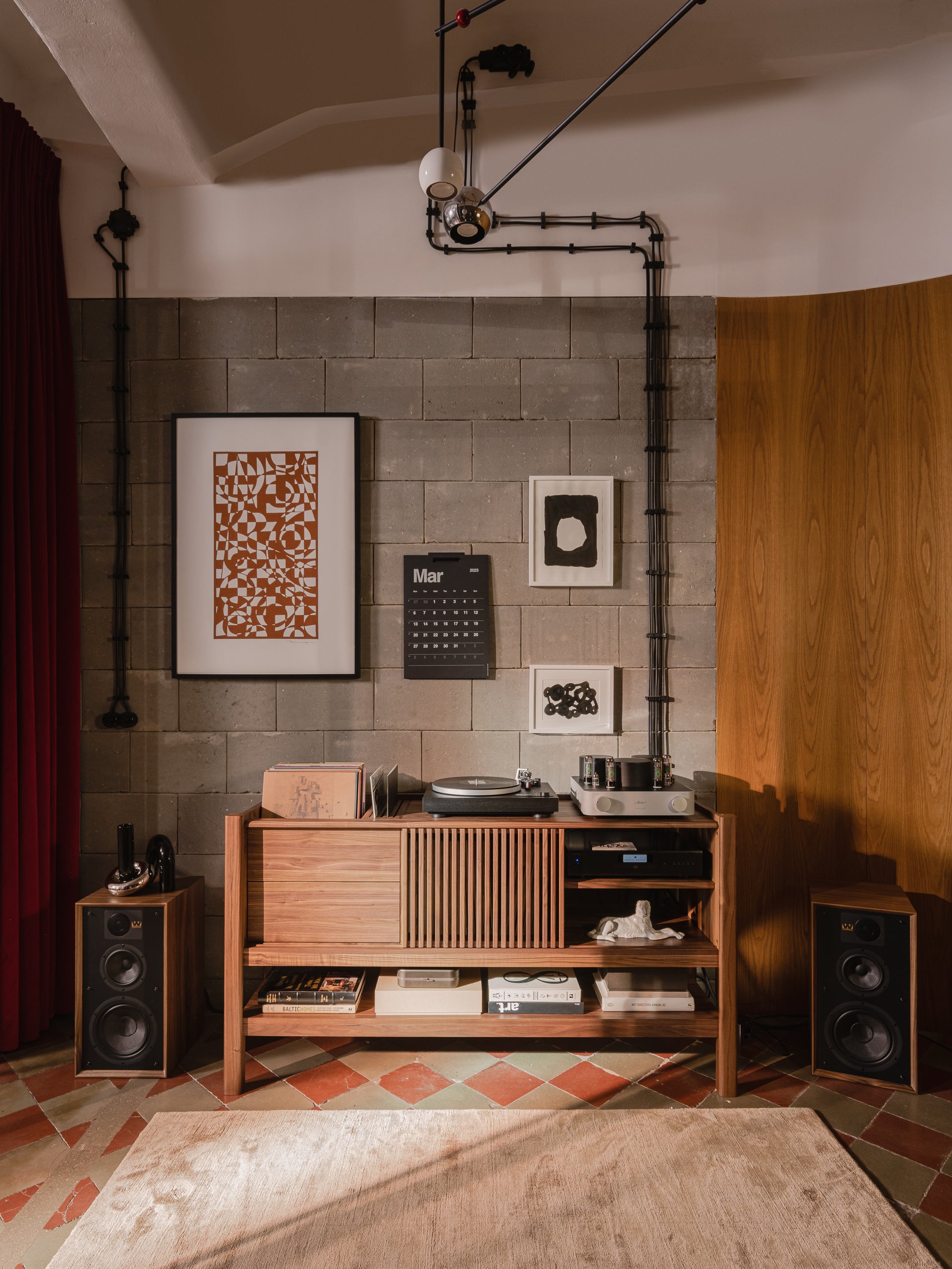 Cozy room with a wooden stereo cabinet, vinyl records, speakers, wall art, and a March calendar.