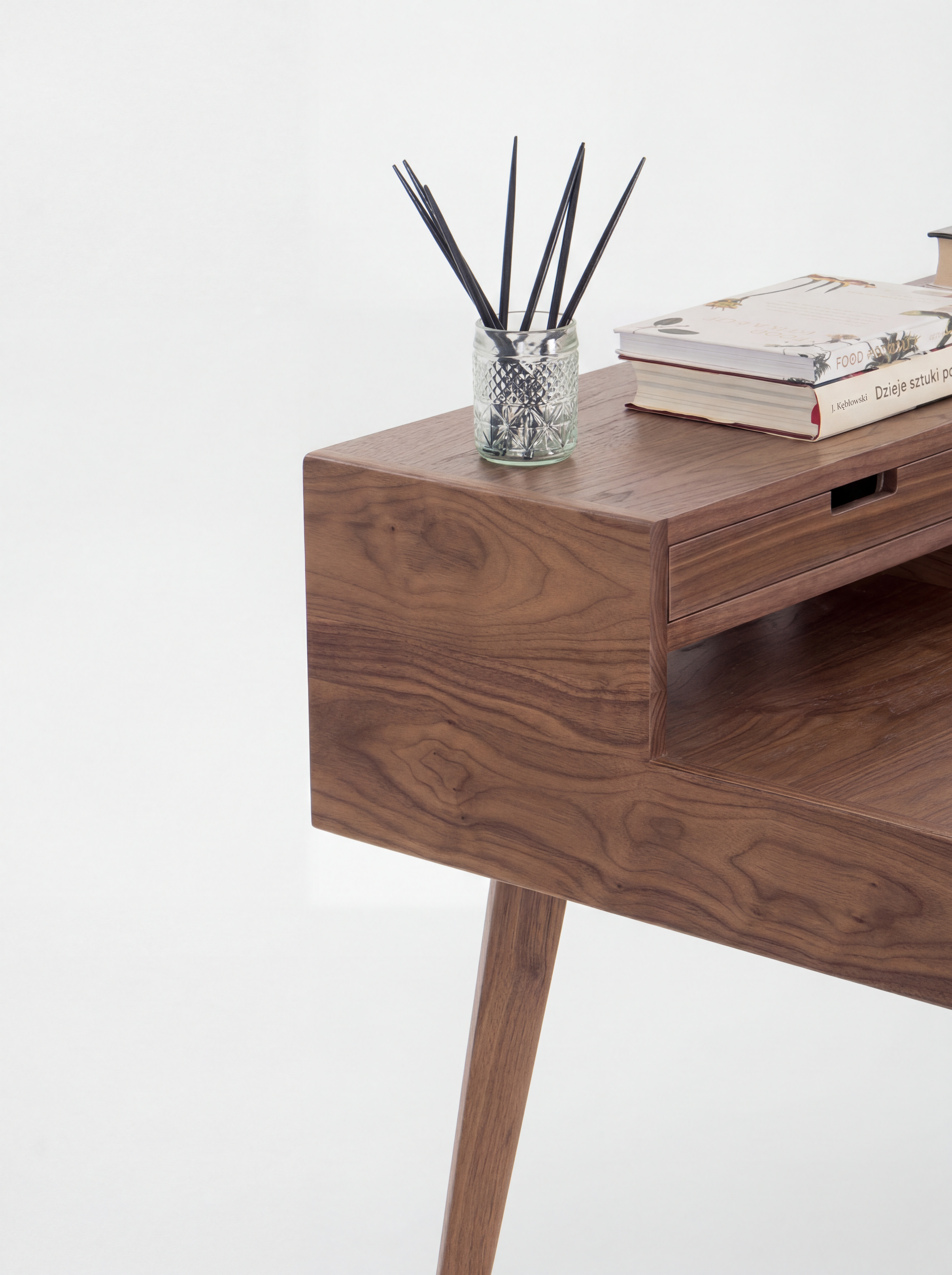 Wooden desk with a book and a pen holder.