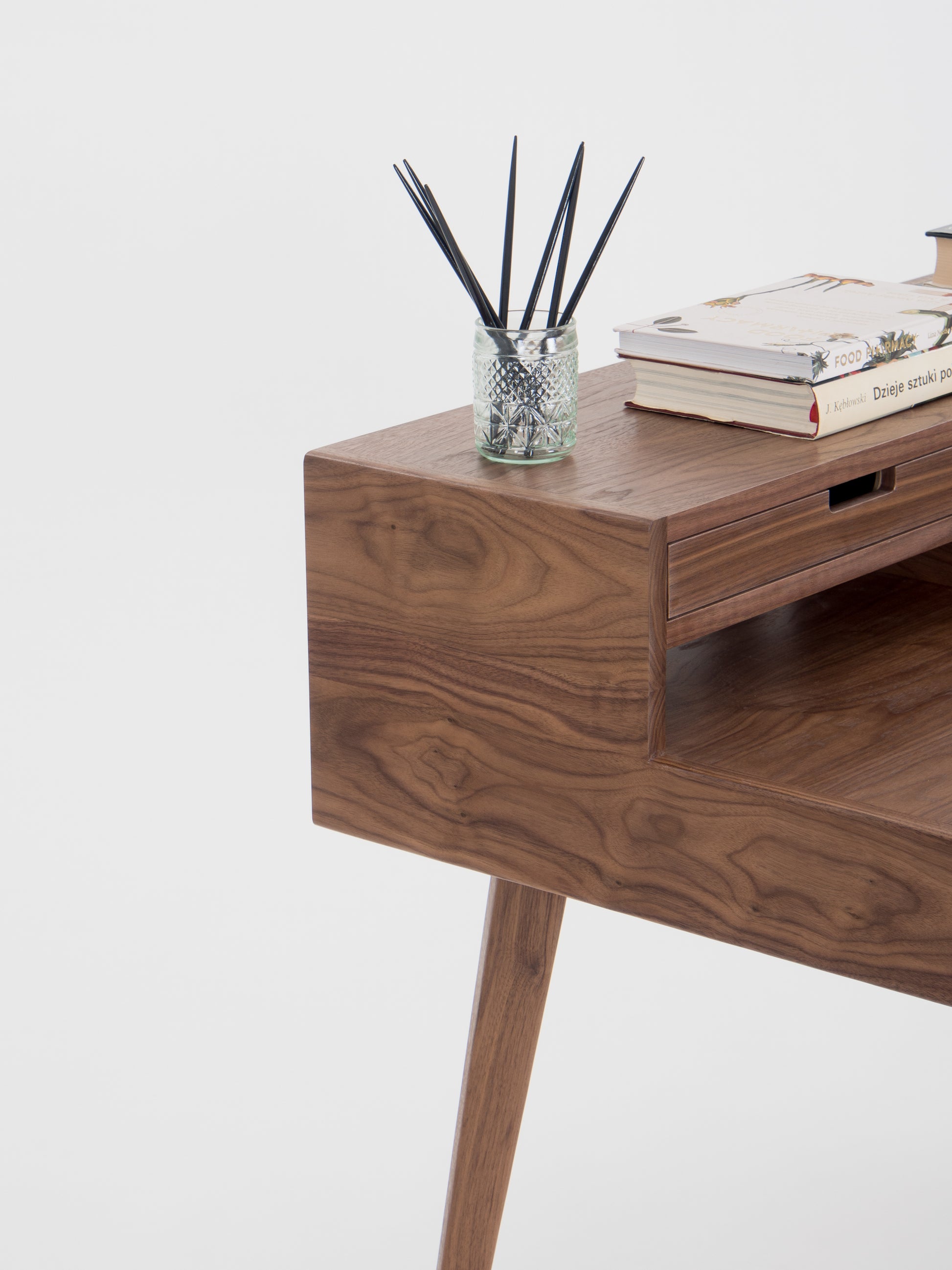 Wooden desk with a book and a pen holder.