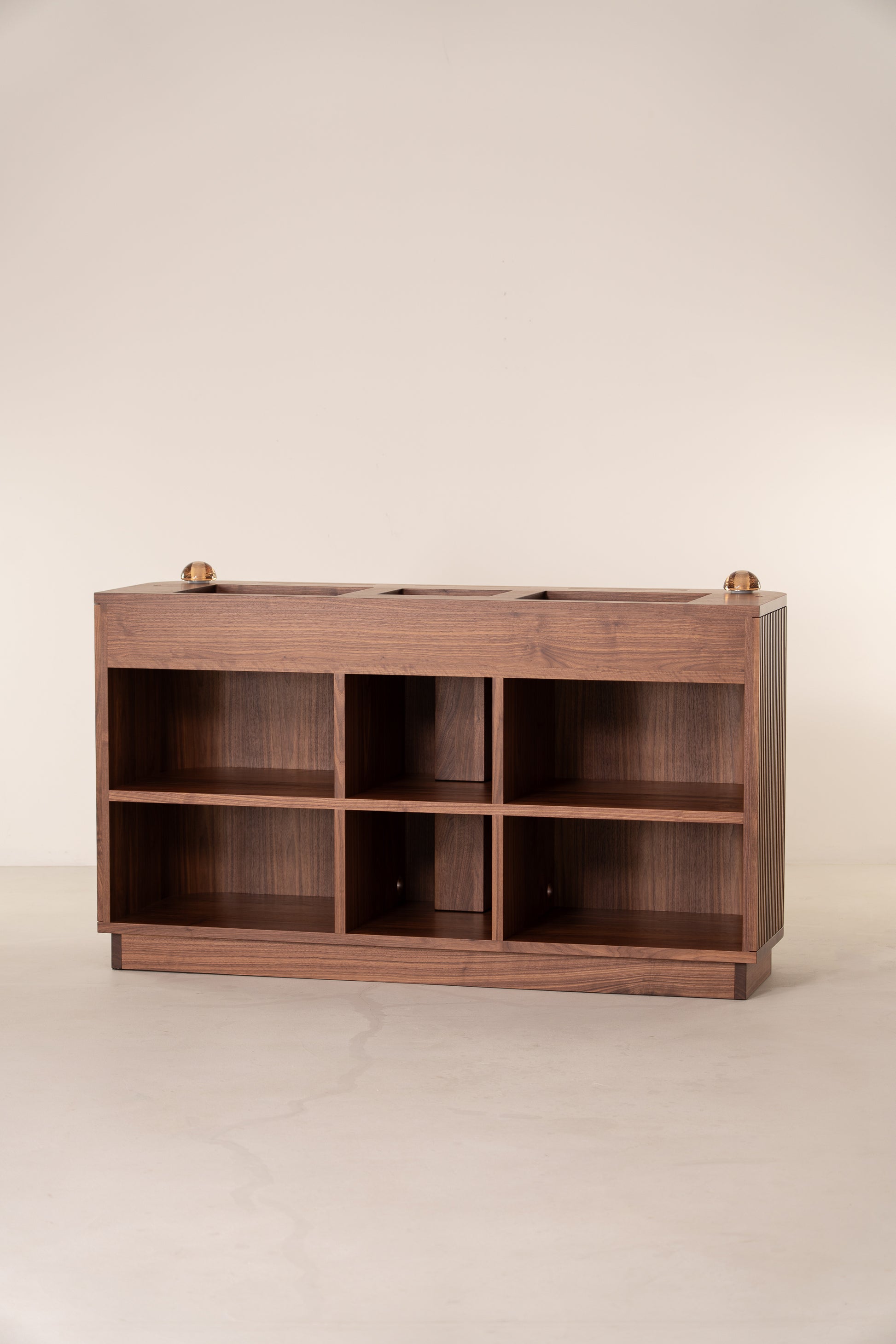 Wooden cabinet with open square shelves and a smooth top, against a plain background.