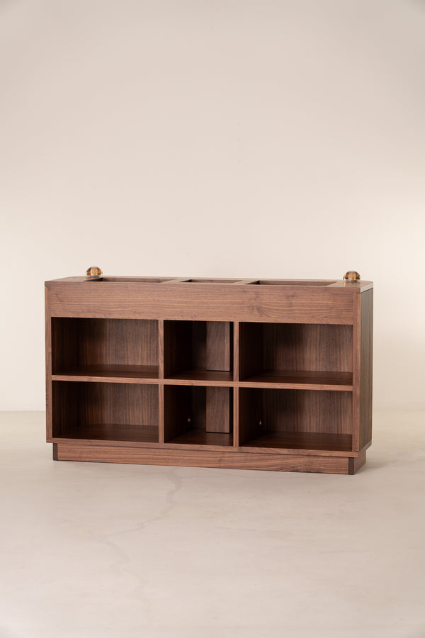 Wooden cabinet with open square shelves and a smooth top, against a plain background.