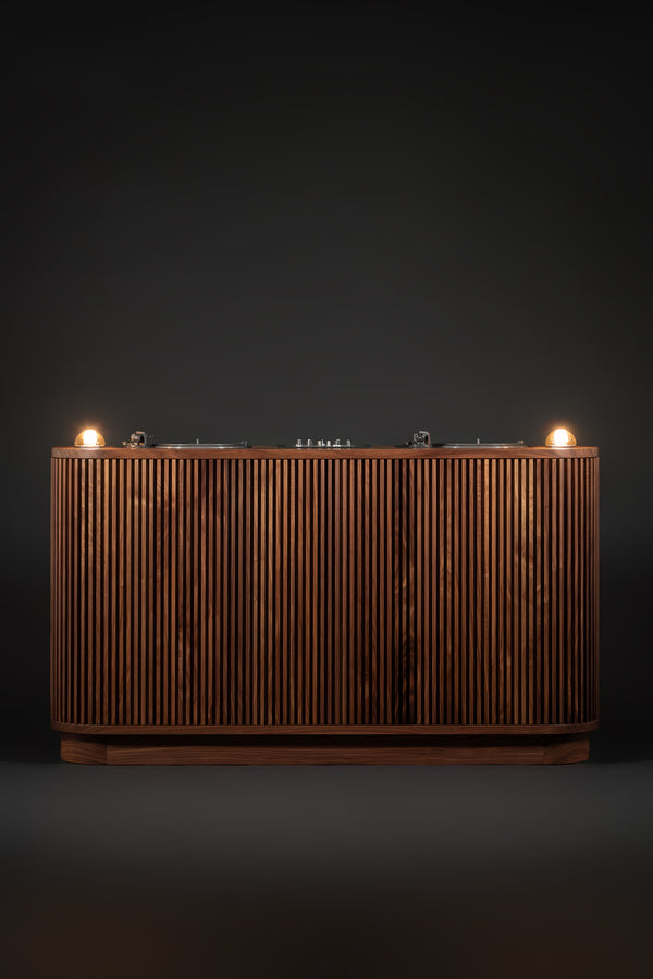 Wooden console with fluted panels and two illuminated bulbs on a dark background.