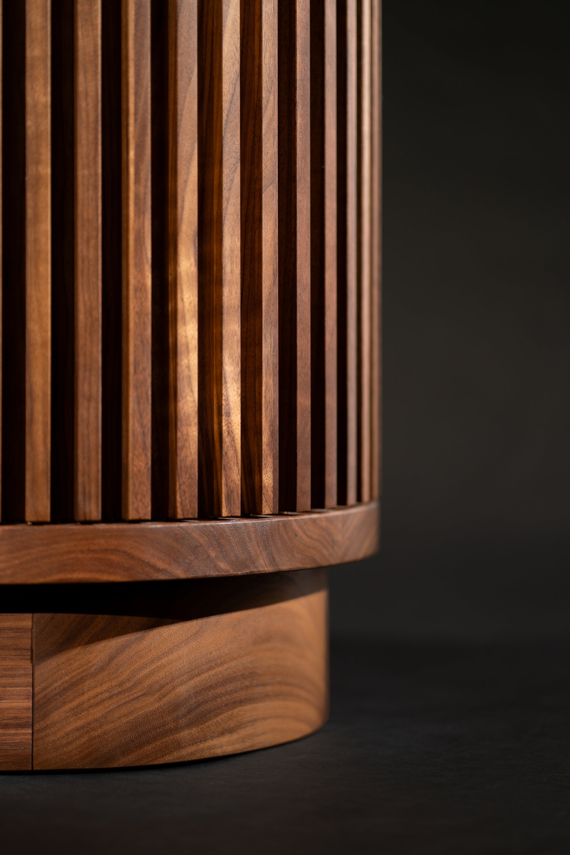 Close-up of a cylindrical wooden object with vertical grooves and a smooth base.