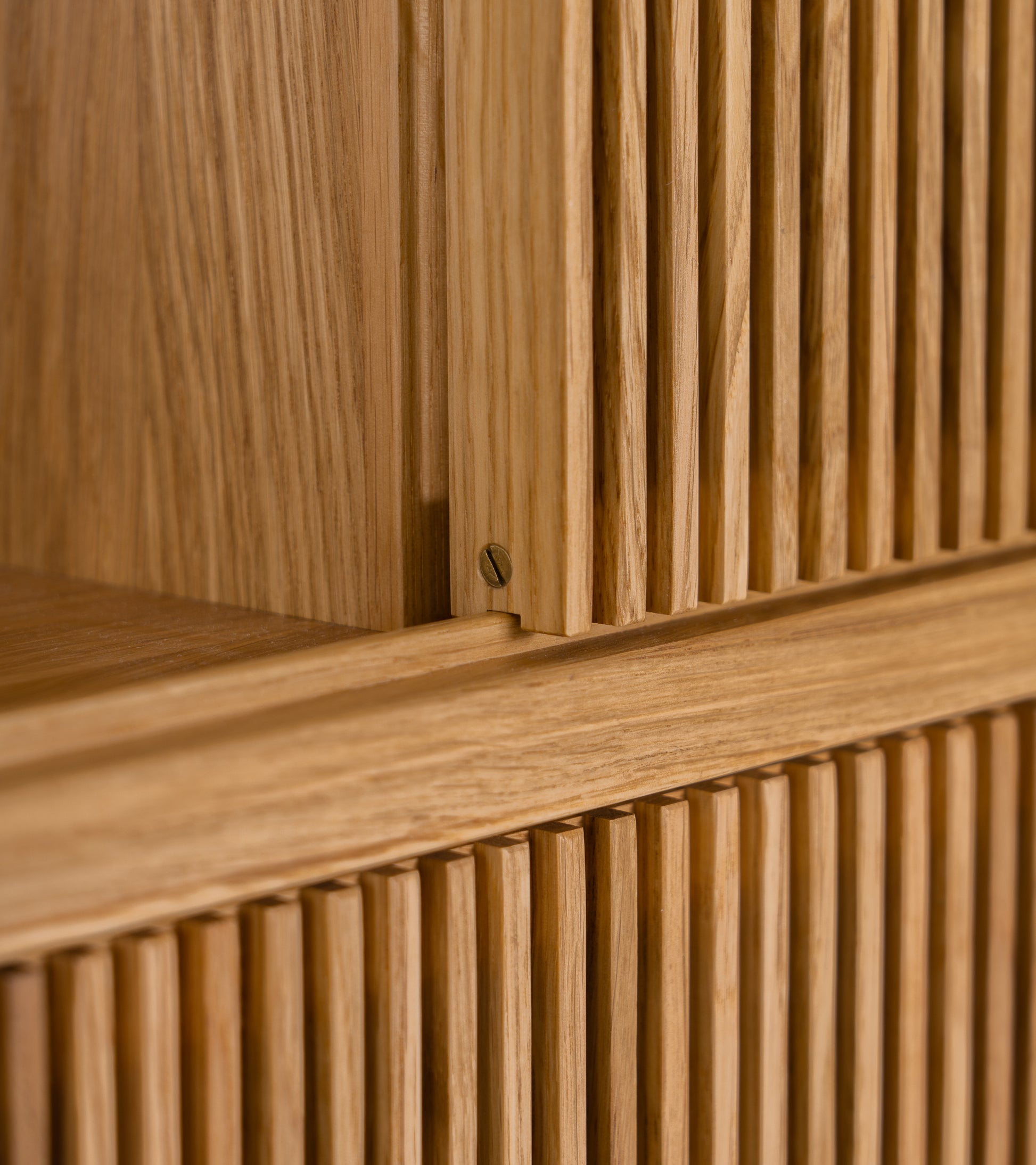 Close-up of wooden slatted texture with a small brass screw.