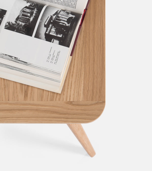 Open book with black-and-white photos on a wooden table.