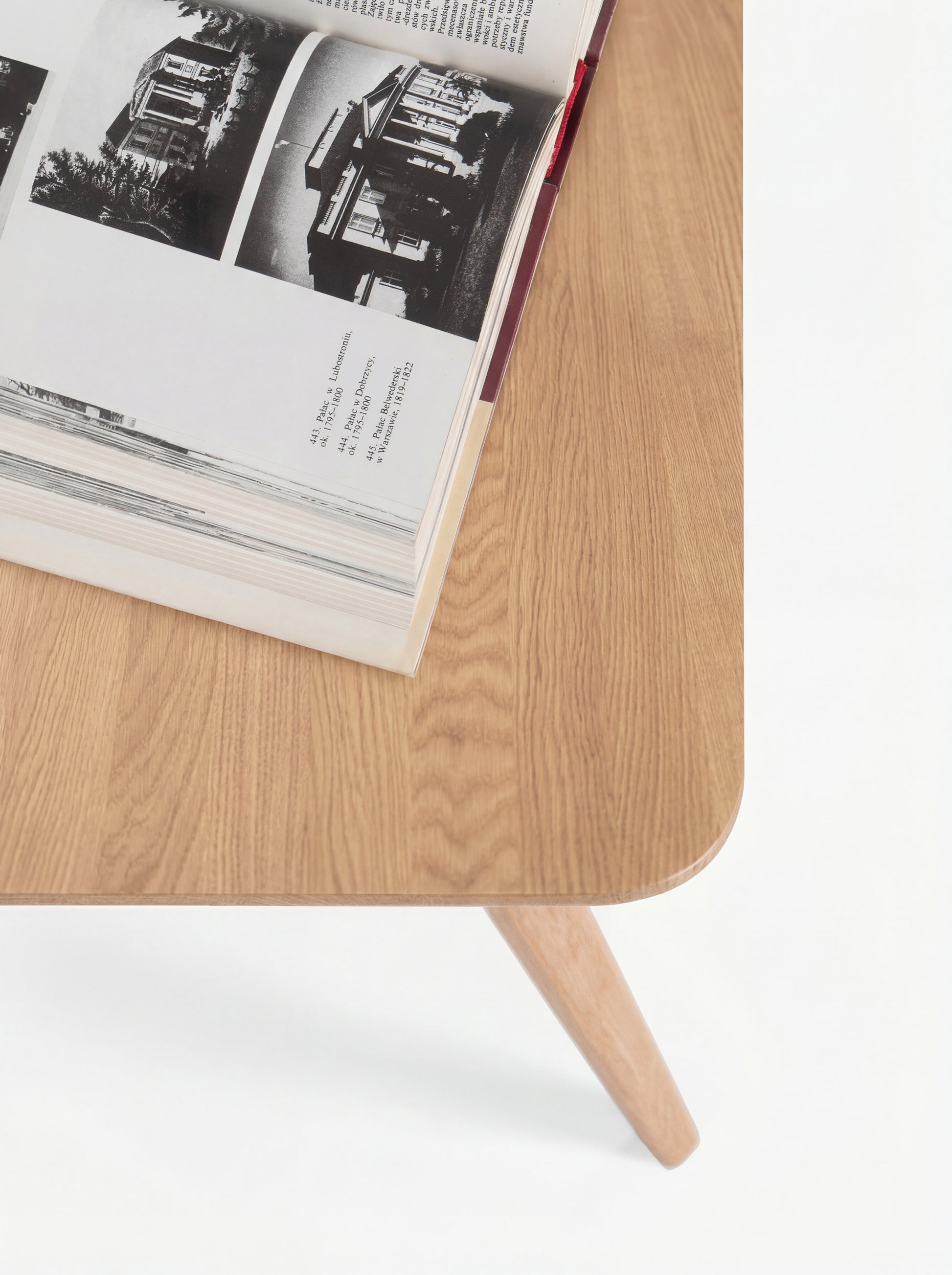Open book with black-and-white photos on a wooden table.