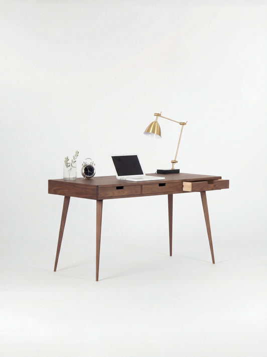 HEIM 140 writing desk in walnut wood, three-quarter view with the right drawer open, a laptop and brass lamp