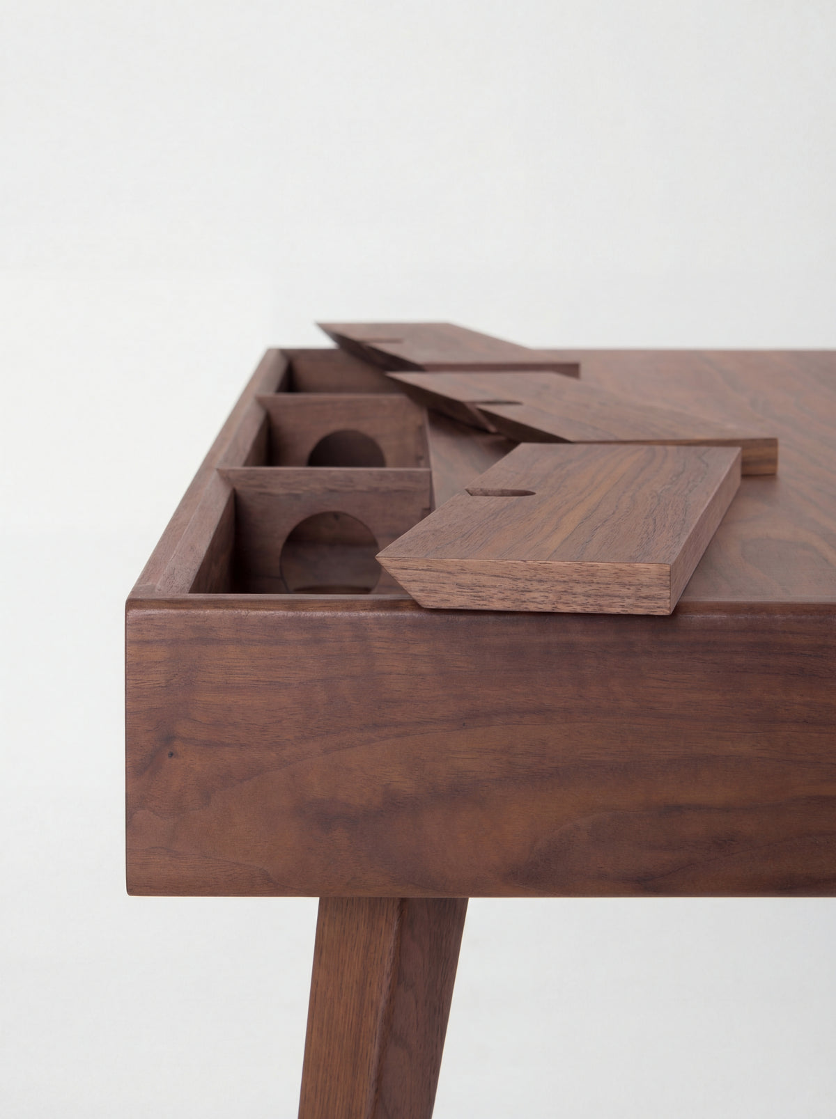 HEIM 140 desk in walnut wood, back corner close-up with all three cable flaps raised and round holes in the compartments