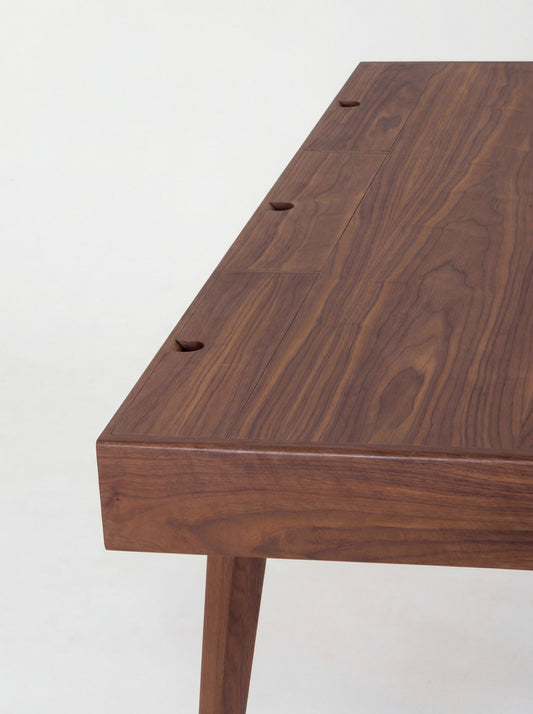 HEIM 140 desk in walnut wood, close-up of three closed cable flaps with semicircular notches along the back edge