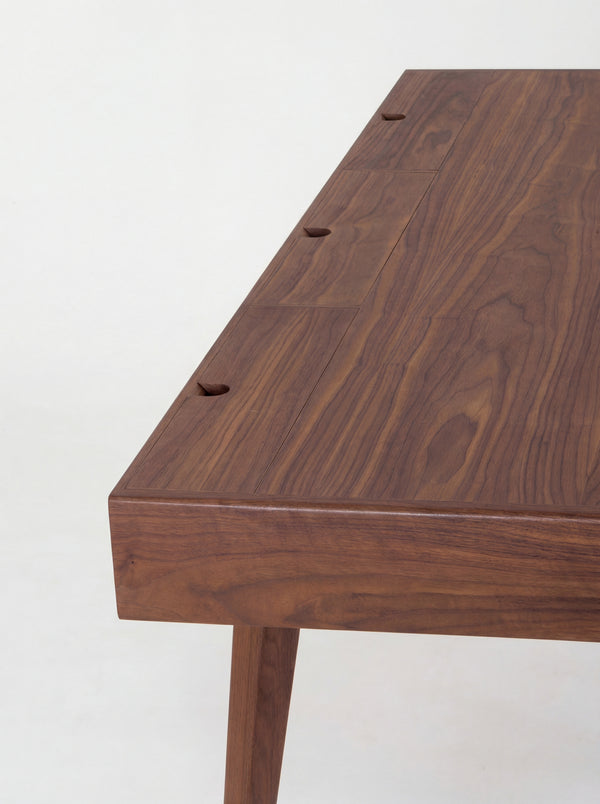 HEIM 140 desk in walnut wood, close-up of three closed cable flaps with semicircular notches along the back edge